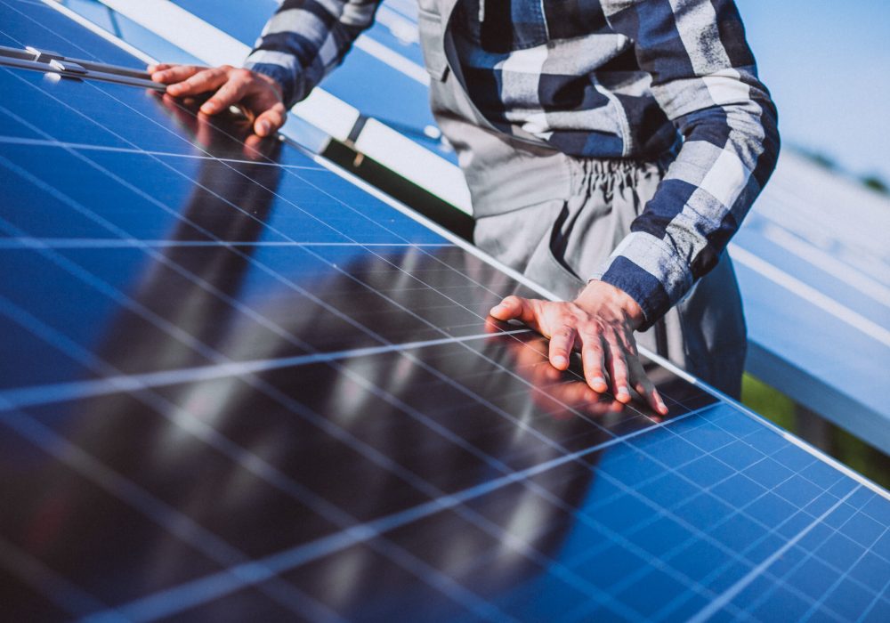 Man worker in the firld by the solar panels